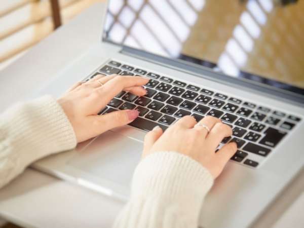 物件を見つけるため、パソコンでウェブ検索している女性の手元